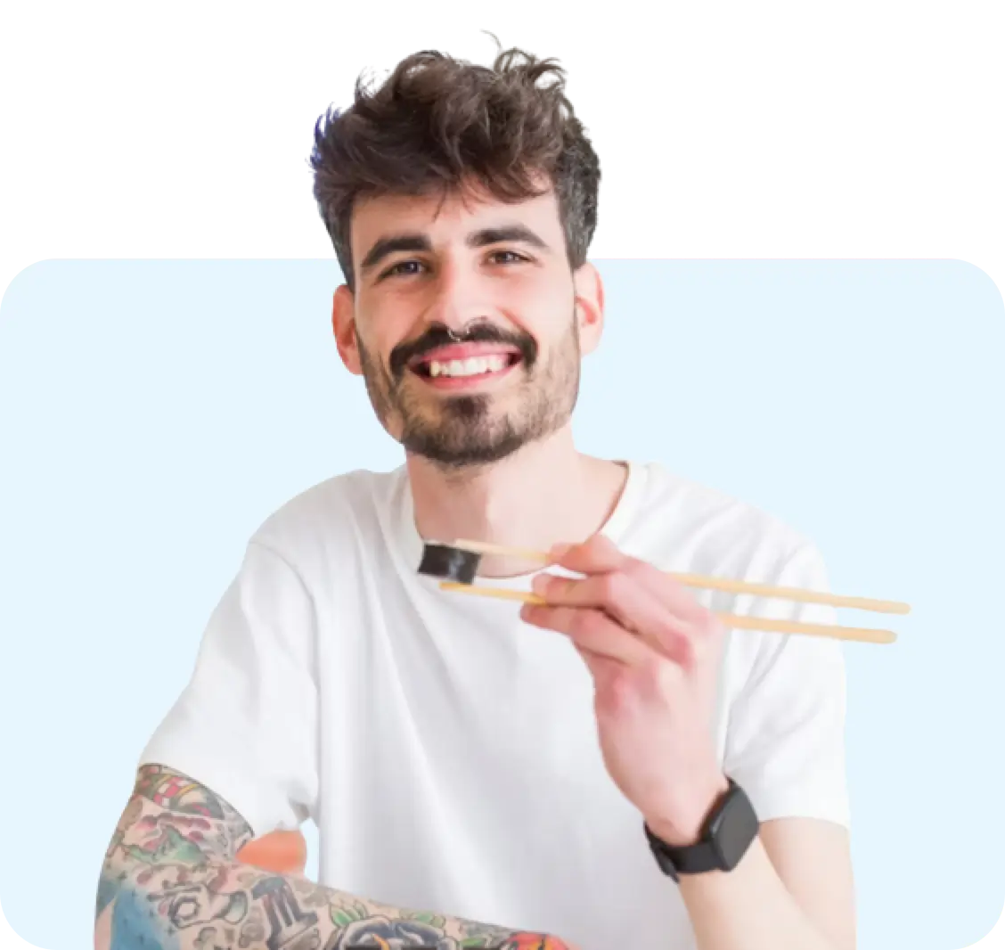 man eating with sticks